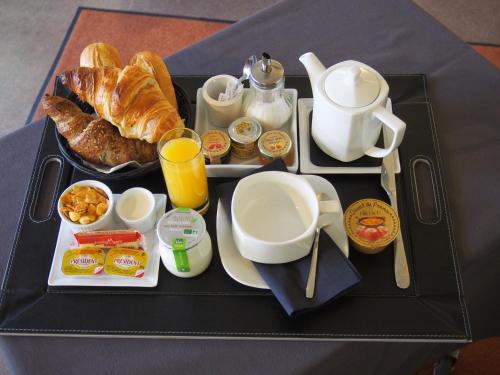 a tray of breakfast food on a table at Hotel Du Croisé in Marcq-en-Baroeul
