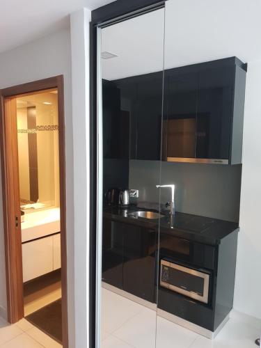 una cucina nera con lavandino e specchio di Club Royal suites a Pattaya North