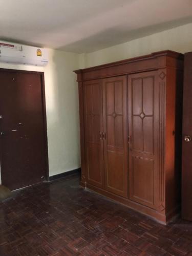 a room with a large wooden cabinet next to a kitchen at Dikachaya Hostel in Chaweng
