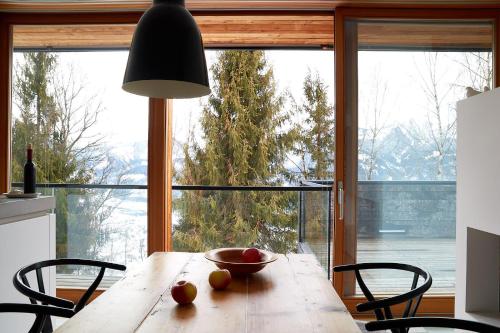 una mesa de madera con un tazón de fruta delante de una ventana en Aufberg 1113, en Piesendorf