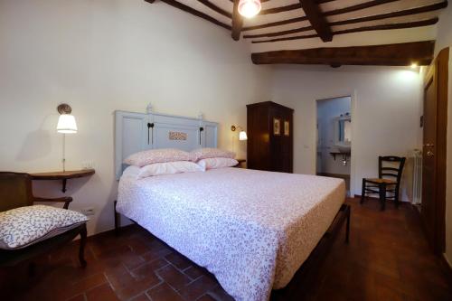 a bedroom with a bed and a table and a chair at Fattoria Poggerino in Radda in Chianti
