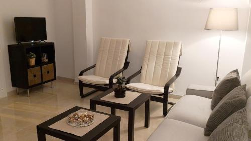 - un salon avec un canapé et deux chaises dans l'établissement Muro de los Navarros 26-Apartamentos, à Séville