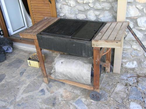 a wooden table with a grill on top of it at VytinaHouse in Vitina