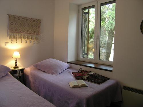 two beds in a room with a window and a book at VytinaHouse in Vitina