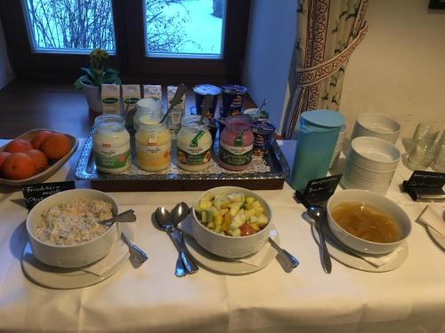 a table topped with bowls of food and spoons at Hörger Biohotel und Tafernwirtschaft in Kranzberg