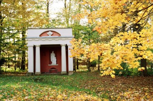 a small red and white building with a statue at Hotel im Kavalierhaus in Machern