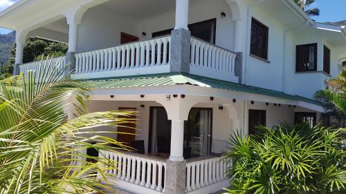 a white house with a staircase on top of it at Drake Seaside Studio Apartments in Bel Ombre