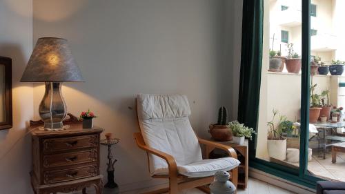 a room with a chair and a lamp on a dresser at On The Lake in Tiberias