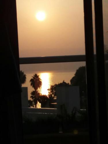 a sunset seen through a window with a view at On The Lake in Tiberias
