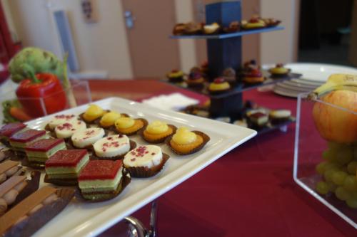 a tray of cupcakes and other desserts on a table at Mercure Epinal Centre in Épinal