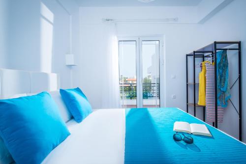 a bedroom with a blue and white bed with blue pillows at W Suites by Estia in Stalís