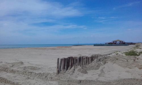 a sandy beach with a gazebo and the ocean at Maria Turistico in Fiumicino