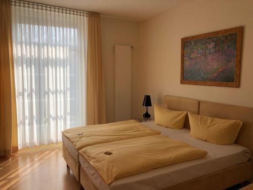 a bedroom with a bed and a large window at Hotel im Kavalierhaus in Machern