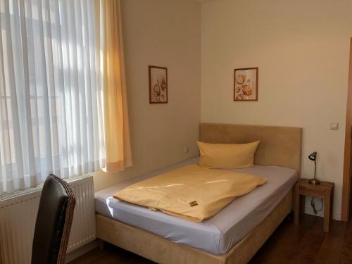 a small bed in a room with a window at Hotel im Kavalierhaus in Machern