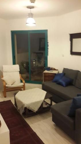 a living room with a couch and a chair at On The Lake in Tiberias