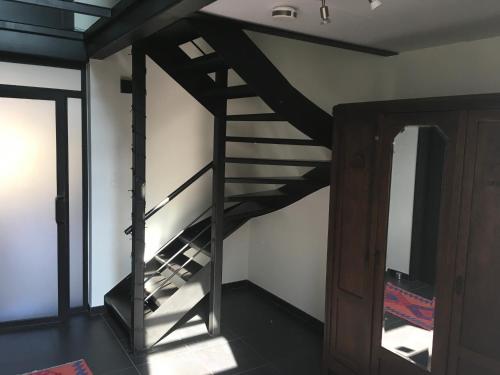 a black spiral staircase in a room with a door at B&B Wannes Suite in Leuven