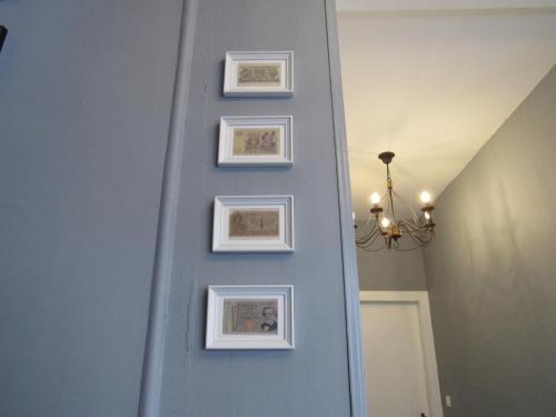 a hallway with framed pictures on a blue wall at Les Deux Rives in Cierp