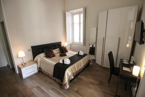 1 dormitorio con cama, escritorio y ventana en B&B Il Ritratto, en Salerno