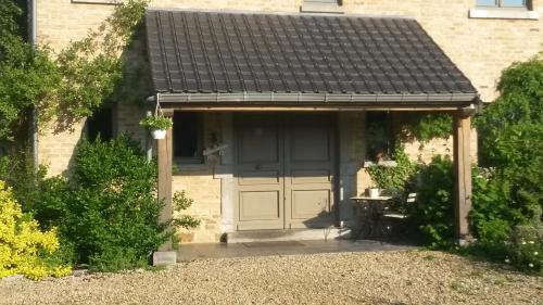 a house with a garage with a black roof at Un brin de Paradis "appartement de 100 m²" in Harzé