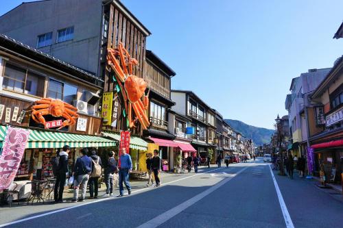 a group of people walking down a city street at Morizuya in Toyooka