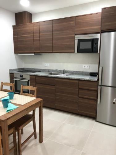 a kitchen with wooden cabinets and a wooden table with a wooden table sidx sidx sidx at Soldouro Guesthouse in Aveiro