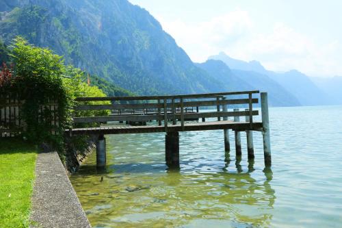 a bench sitting in the water next to a lake at Seegasthof Hois'n Wirt - Hotel mit Wellnessbereich in Gmunden