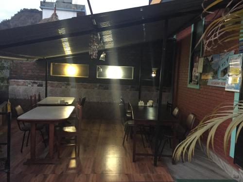 a restaurant with two tables and chairs in a room at Harry Guest House & Restaurant in Pokhara