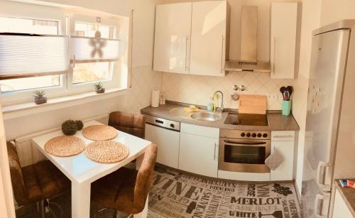 a small kitchen with a table and a sink at Apartment Messe Karlsruhe in Rheinstetten