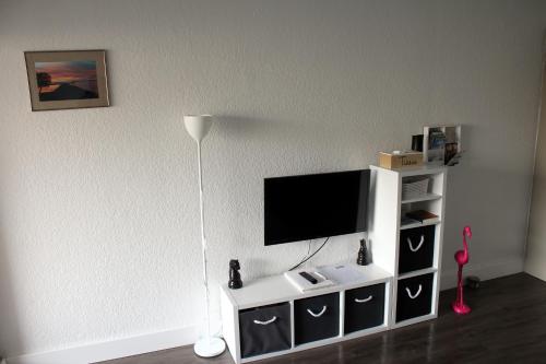 a living room with a tv on a white entertainment center at Studio 237 Port Camargue, Piscine, Climatisation, 2 personnes in Le Grau-du-Roi