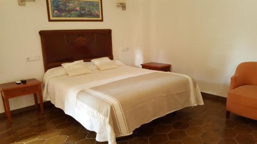 a bedroom with a large bed and a chair at Agroturismo Finca Son Amora in Palma de Mallorca