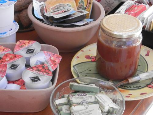 a table with a jar of honey and bowls of candy at Agriturismo Salento D'Arare in Marina Serra