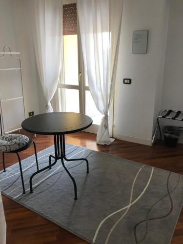 a table and chair in a living room with a rug at Guesthouse Flora in Lodi