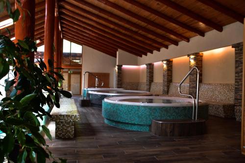 a large bathroom with three tubs in a building at Kőkapu Vadászkastély és Hotel & Apartments in Nagyhuta