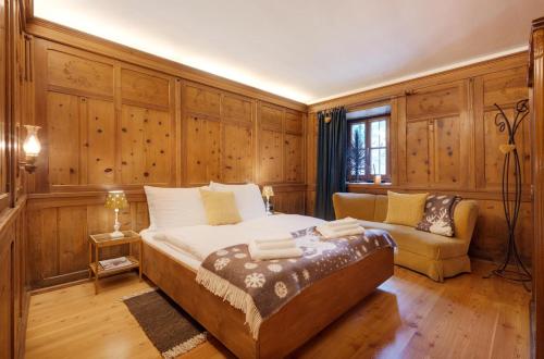 a bedroom with a large bed and a couch at Chaletapartement Ambiente Villa Mozart in Chienes