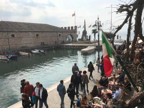 a group of people standing around a body of water at Lacisivm Lake View in Lazise