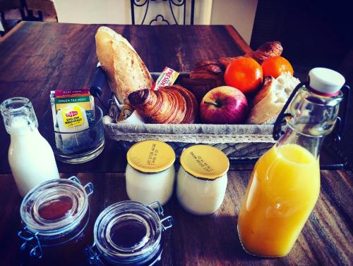a table topped with a basket of bread and orange juice at Hotel Alexandra - Boutique Hotel in Juan-les-Pins