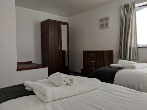 a hotel room with two beds with towels on them at Kings Lodge in Telford