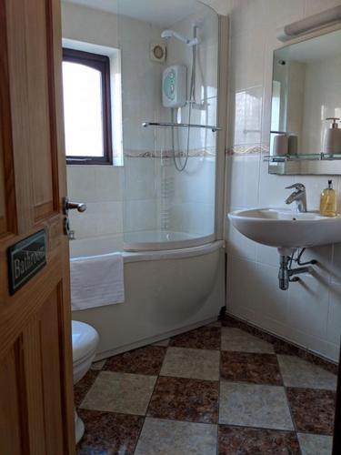 a bathroom with a tub and a sink and a shower at Kings Lodge in Telford