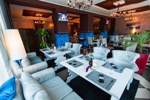 a living room with couches and tables in a restaurant at Armavir Hotel in Armavir