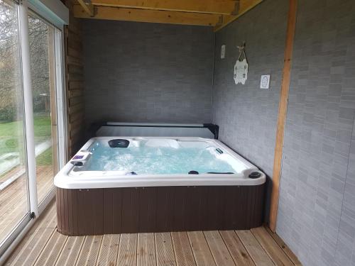 a jacuzzi tub in a room with a window at Gite la Baudrière in Livaie