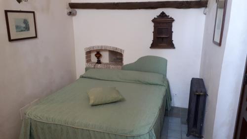a small bedroom with a green bed with a pillow at Agriturismo La Torre Rossa in Itri