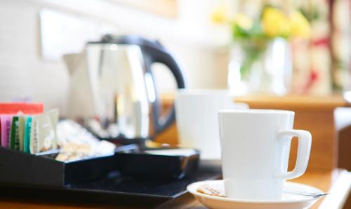 a table with two coffee cups and a tea pot at Riviera Town House in Scarborough