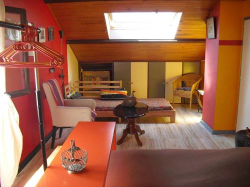Zimmer mit einem Bett und einem Zimmer mit einem Tisch in der Unterkunft La Maison Imparfaite in Fourbanne