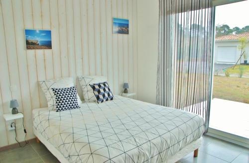 a bedroom with a bed and a large window at Villa Donosti Chambres d'Hôtes in Lanton