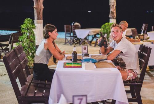 a man and a woman sitting at a table at Lanta Nice Beach Resort - SHA Extra Plus in Ko Lanta