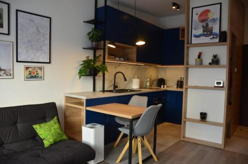 a small kitchen with a table and a couch at Apartament Polka Dots in Krakow