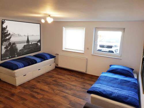 a bedroom with two beds and a large picture on the wall at Monteurzimmer Obersulm in Obersulm