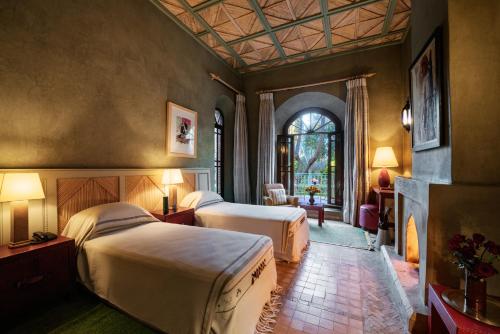 um quarto de hotel com duas camas e uma lareira em Dar Zemora em Marraquexe