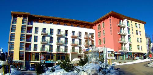 a large building with snow in front of it at Apartmán Crocus 313 in Štrbské Pleso