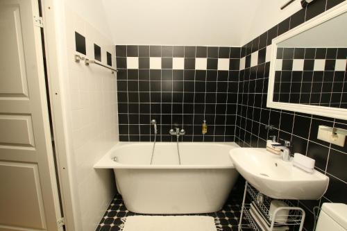 a black and white bathroom with a tub and a sink at Meke in Mustkalni